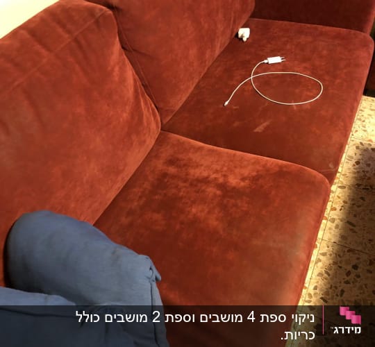 ספה אדומה עם כתמים וכריות כחולות